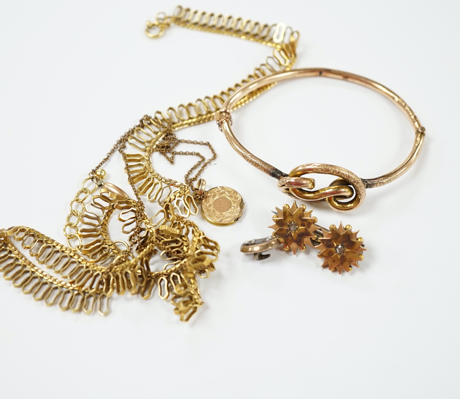 A 9ct. gold fringe necklace, 49cm(a.f.) a 9ct. gold bangle, 25.9 grams, a gold plated locket on a gold plated fine chain, a Victorian yellow metal and two stone diamond set brooch and a stick pin head.